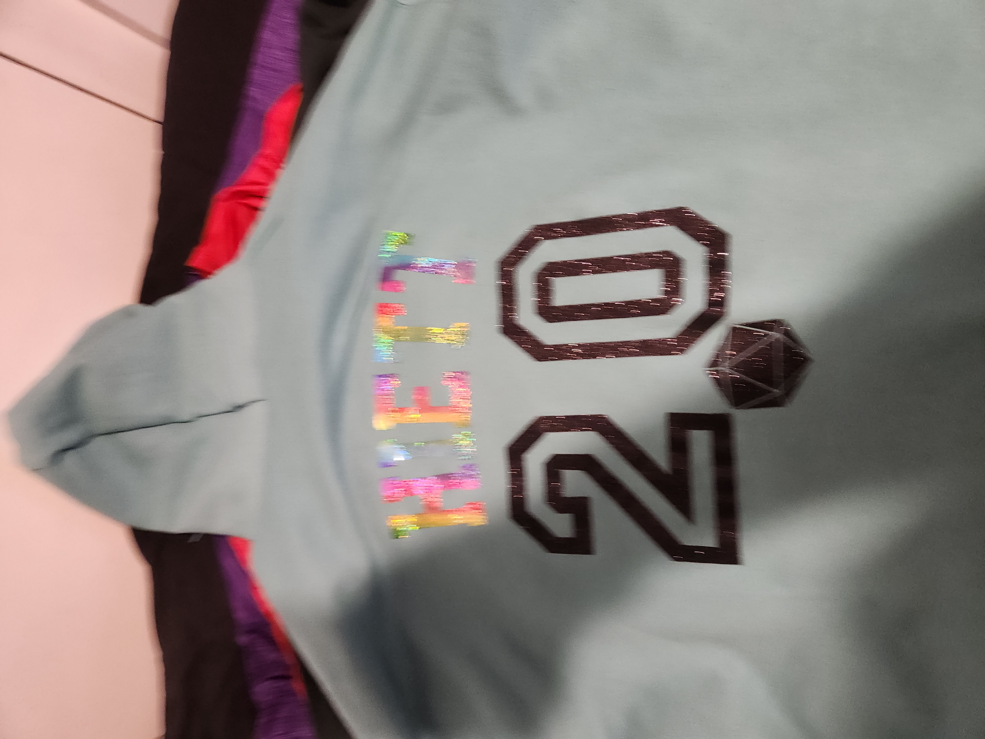 Mint-green hoodie with a holographic HIETT name, the number 20, and a twenty-sided die