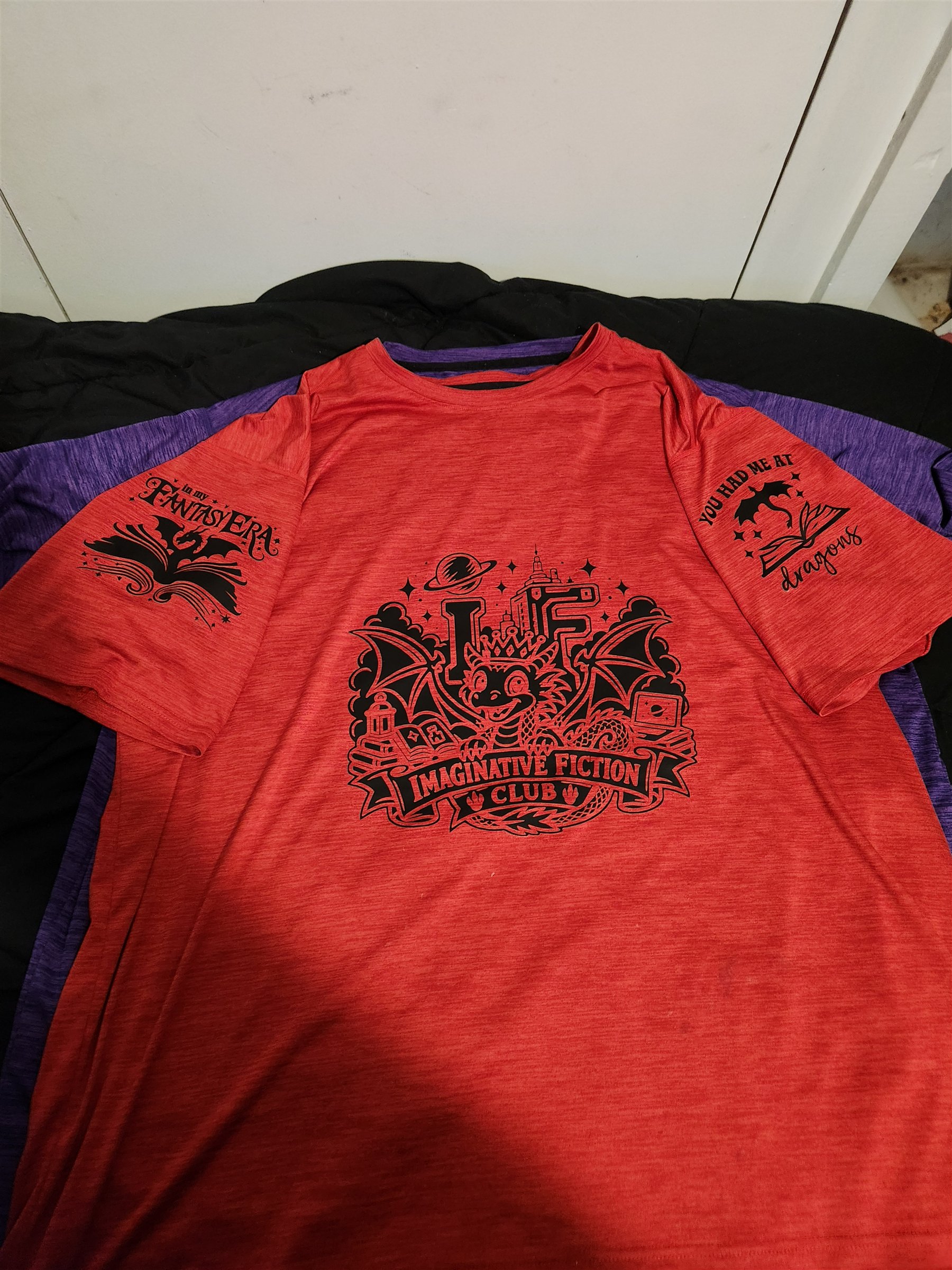 My red shirt with a large black Imaginative Fiction Club dragon design and smaller fantasy and dragon designs on both sleeves