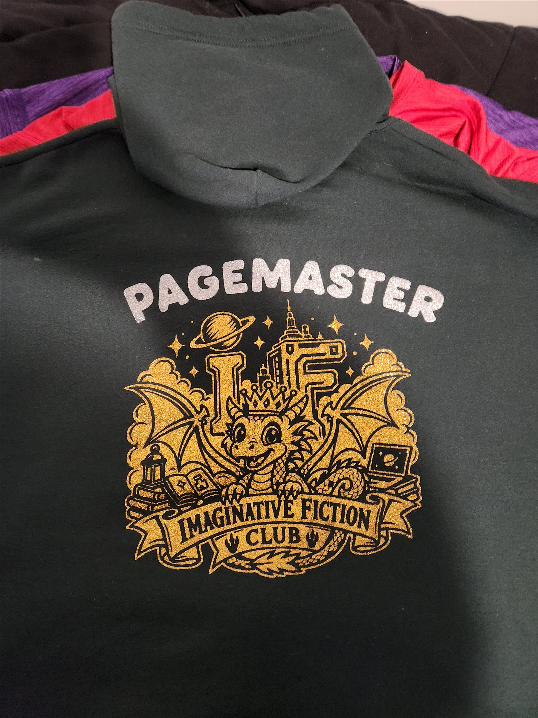 Back of my black hoodie with a silver Pagemaster title and a gold Imaginative Fiction Club dragon design